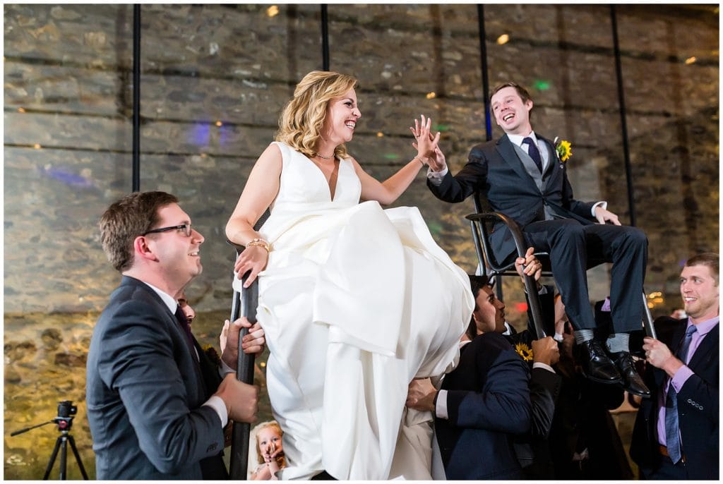 Bride and groom being lifted in chairs on the dance floor for the Hora dance