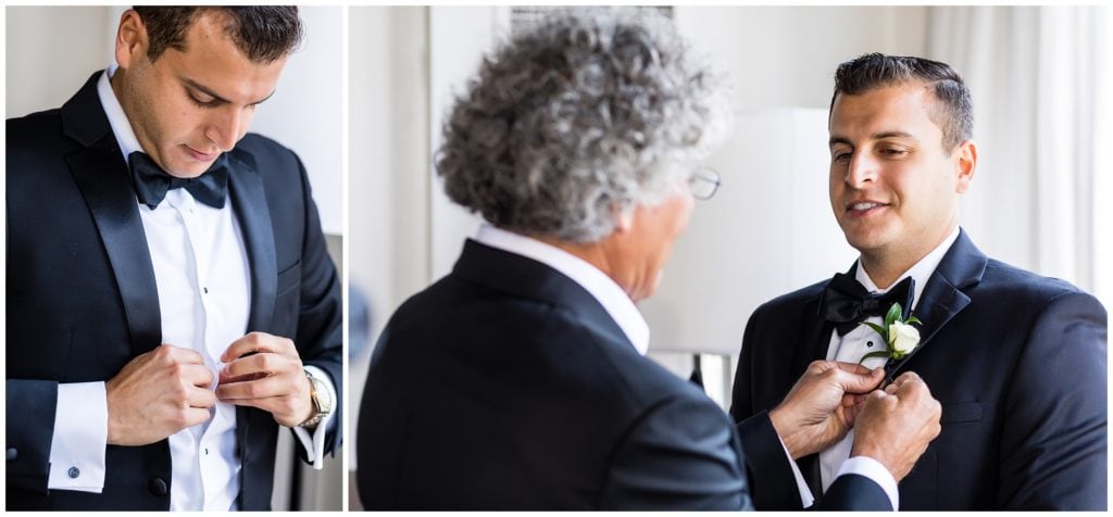 Groom buttoning his shirt and father of the groom pinning on his boutonniere