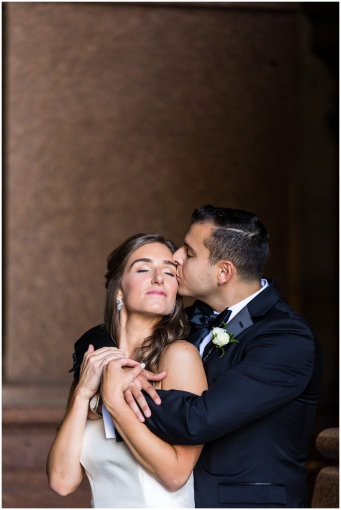 Groom kissing bride on the cheek portrait in Philadelphia City Hall