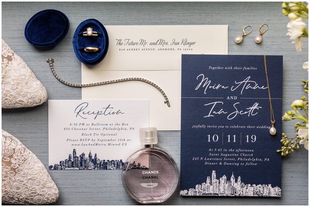 Navy blue and white wedding invitation suite with Philadelphia skyscrapers, wedding shoes, wedding bands, jewelry, and perfume