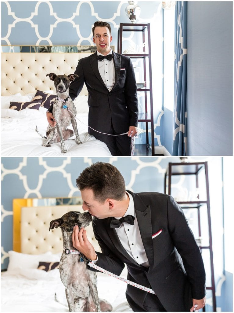 Groom playing with and kissing his dog before wedding