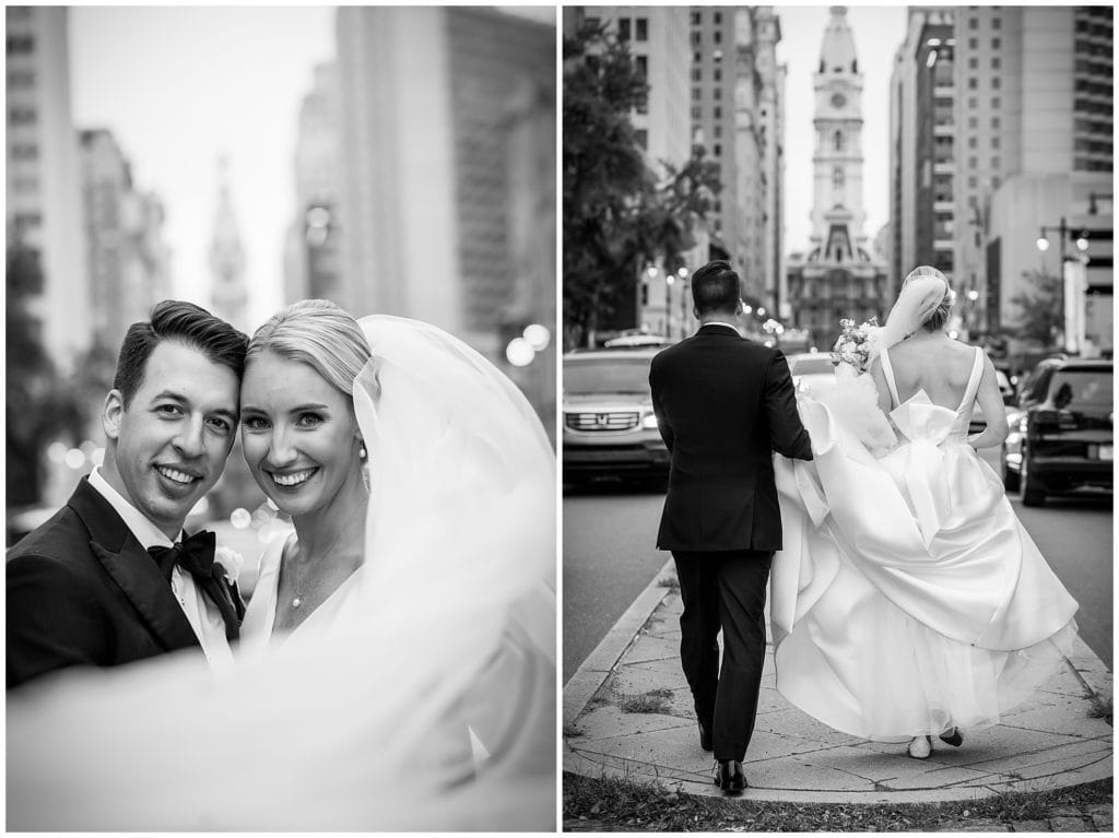 Black and white veil shot and groom helping bride with dress on Broad Street in Philadelphia
