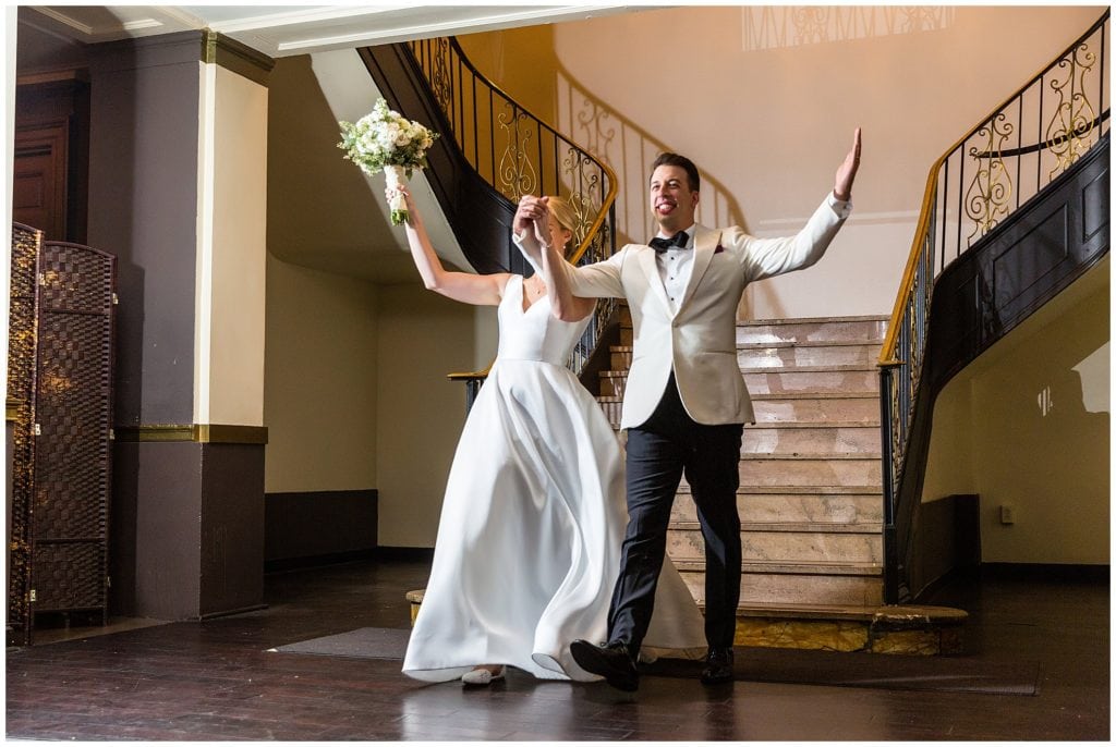 Bride and groom make grand entrance down staircase at Ballroom at the Ben wedding reception