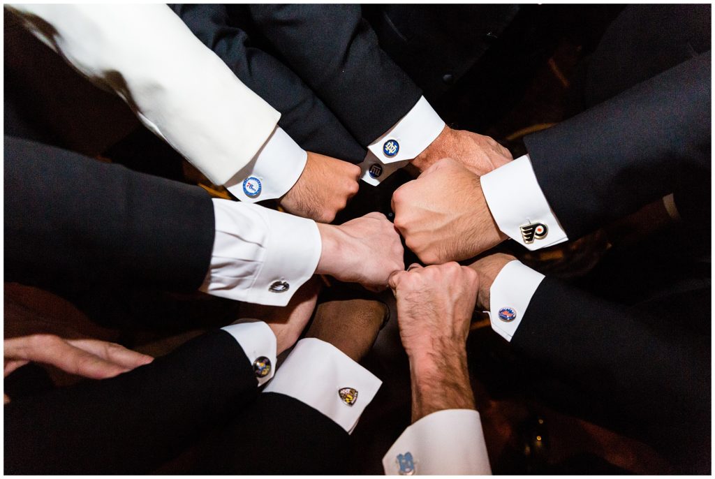Groomsmen with custom sports cufflinks out hands together