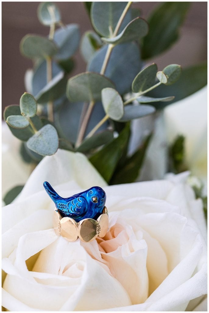 Little blue bird in brides ring on bridal florals