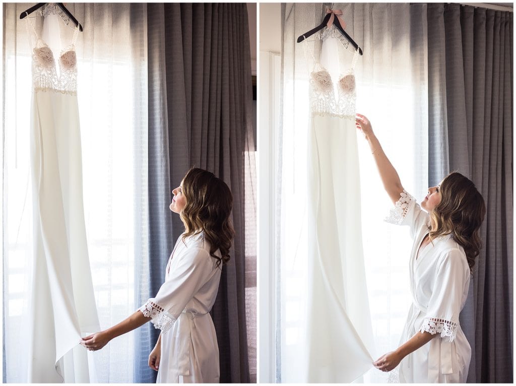 Bride admiring and reaching for her wedding gown