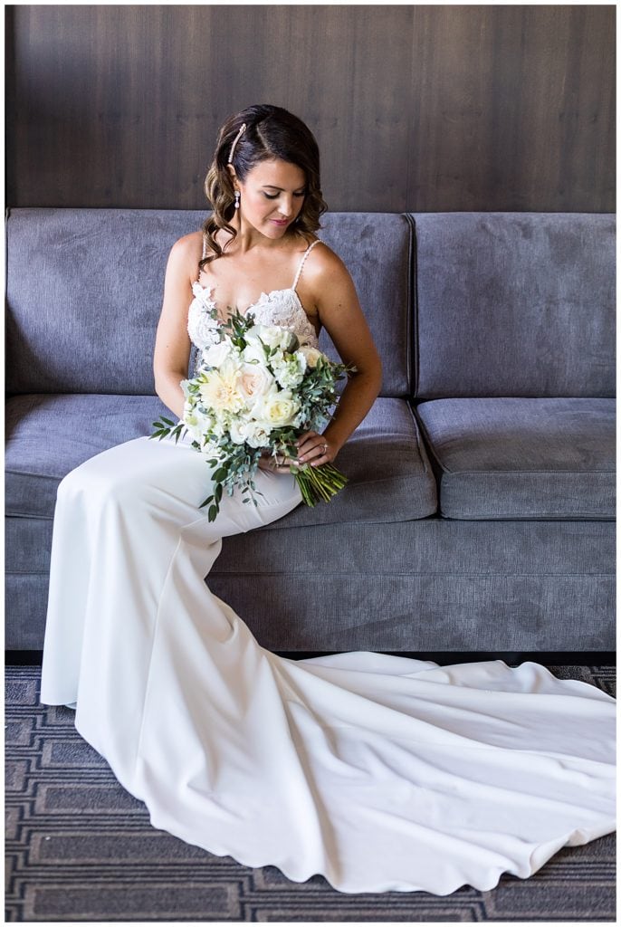 Traditional window lit bridal portrait with long dress train and bridal bouquet