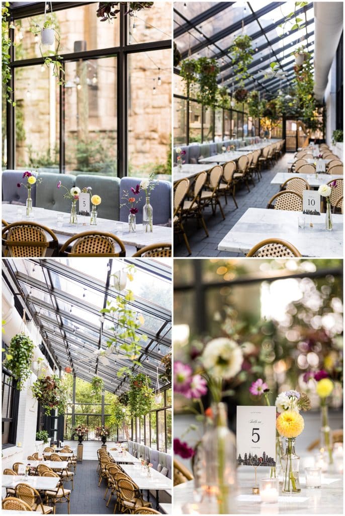 Osteria wedding reception aisle and table setup with lavish greens and delicate floral centerpieces, and Philadelphia skyline table cards