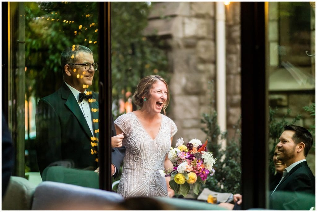 Father of the groom walking bride down the aisle, bride laughing with happiness as she walks down the aisle at Osteria wedding ceremony
