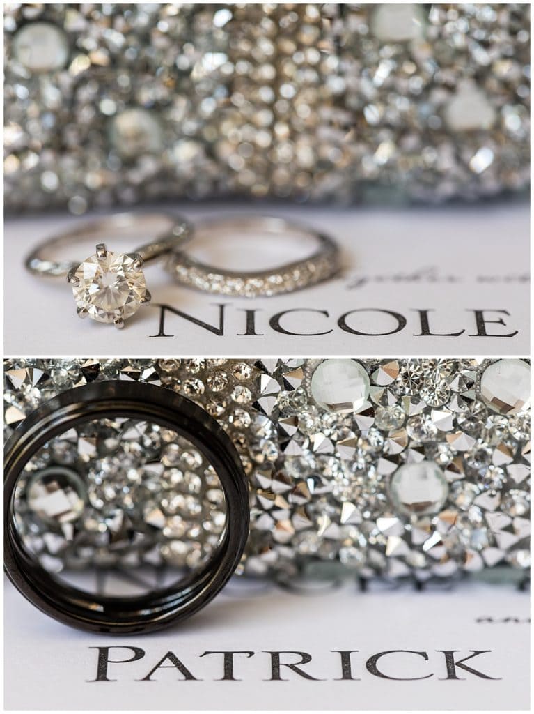 Bride and grooms wedding bands and engagement ring next to names on wedding invitation