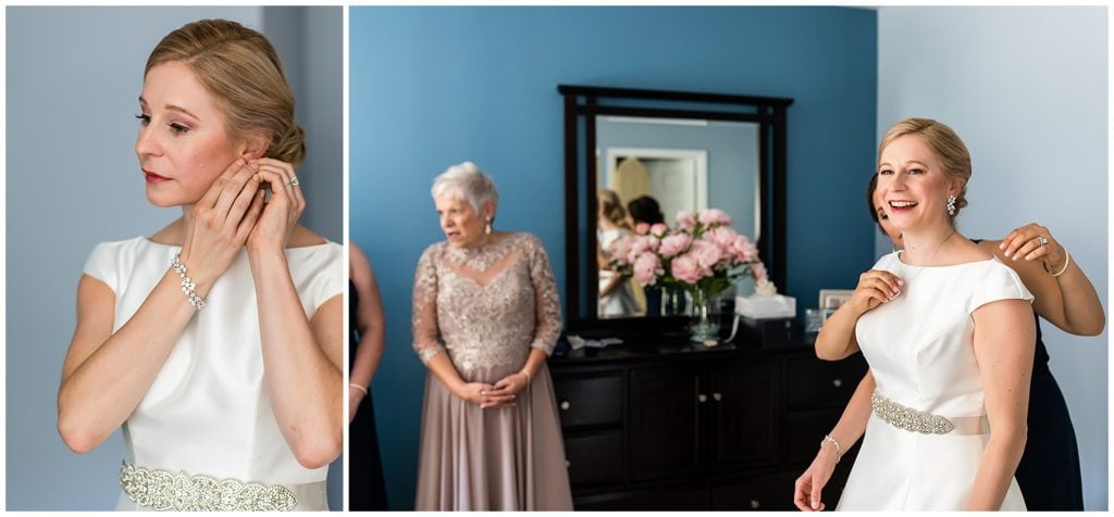Bride putting on her earrings and necklace with help from a bridesmaid
