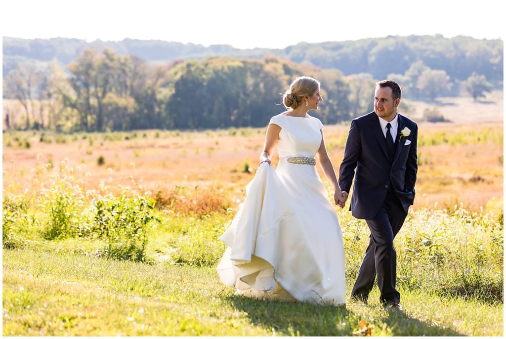 Bride and groom walking together through Valley Forge National Park