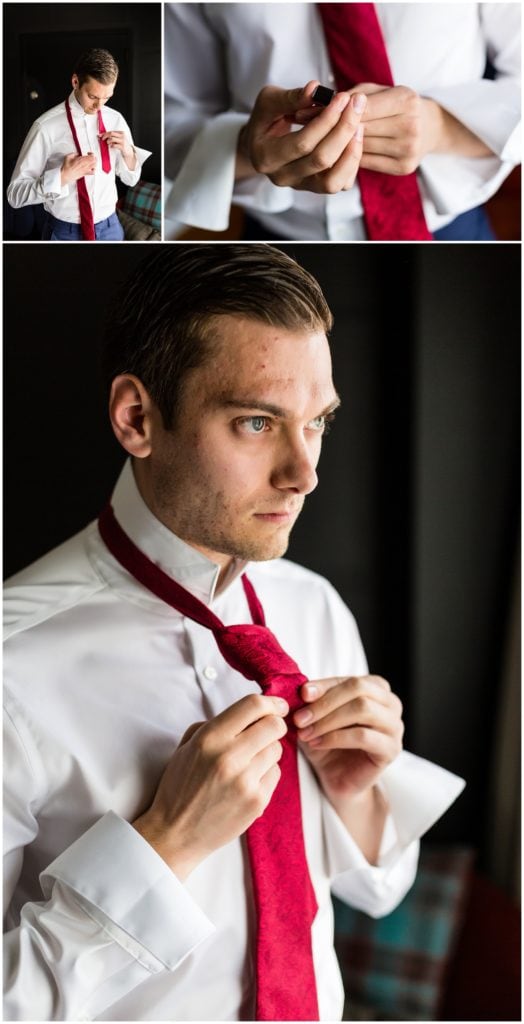Window lit groom portrait of groom tying his tie and getting ready