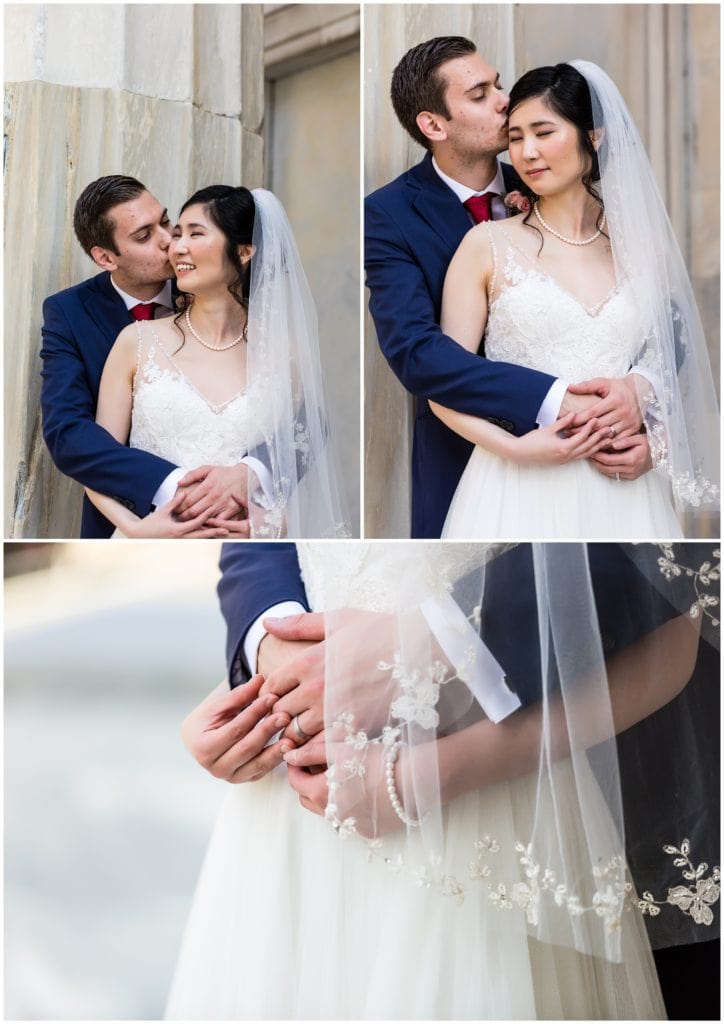 Bride and groom portrait hugging from behind with wedding band and veil details
