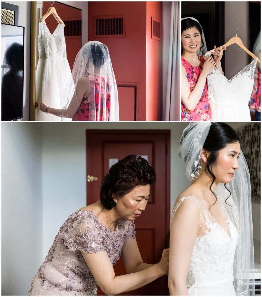 Bride putting on her wedding gown with mother buttoning the back