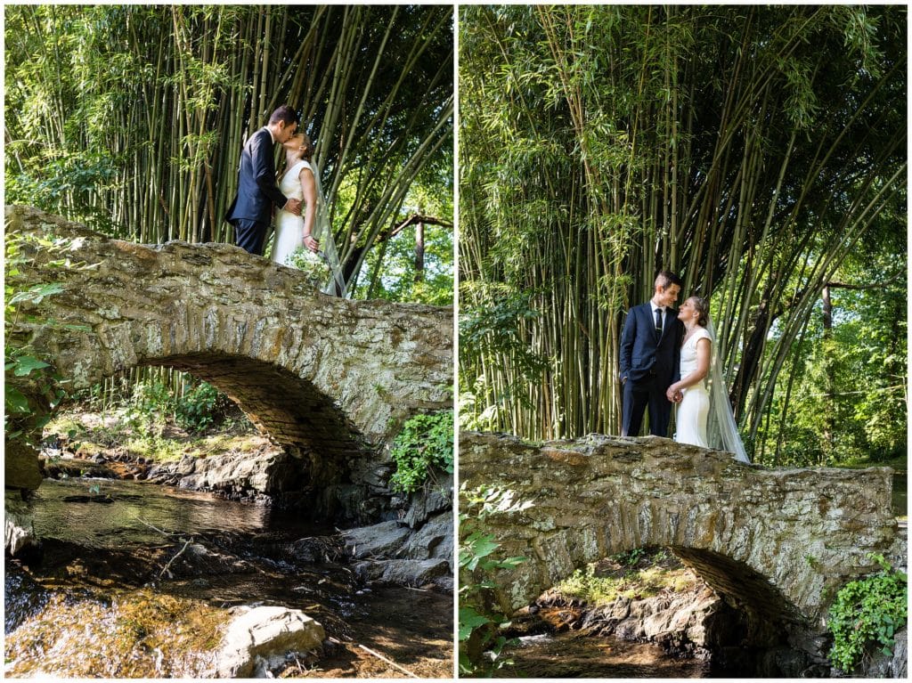 Bride and groom kissing and smiling at each other on stone bridge above creek at the Old Mill