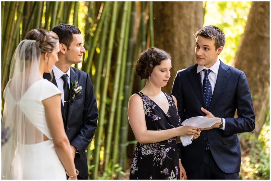 Grooms family and friends doing a reading during outdoor wedding ceremony at the Old Mill