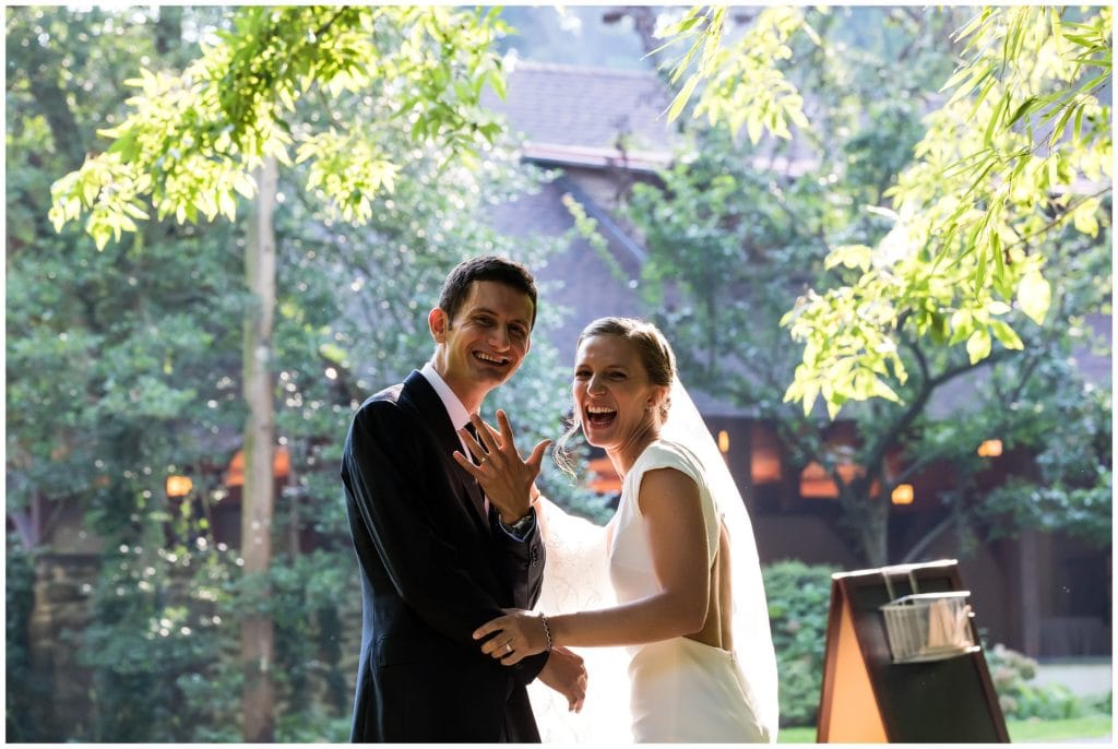 Happy bride and groom show off their wedding bands after outdoor wedding ceremony at the Old Mill