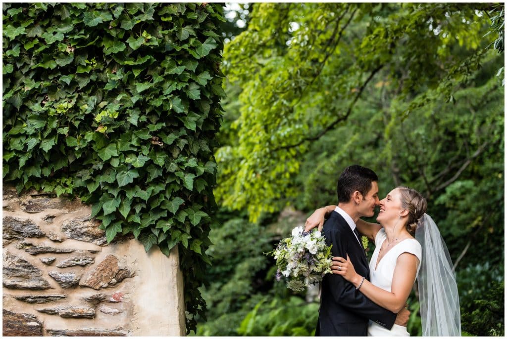 Traditional bride and groom wedding portrait smiling and laughing together outside in greenery at Old Mill