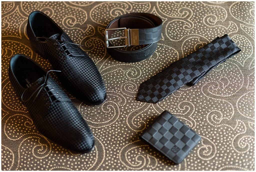 Groom wedding accessories with matching patterned shoes, belt, tie, and wallet
