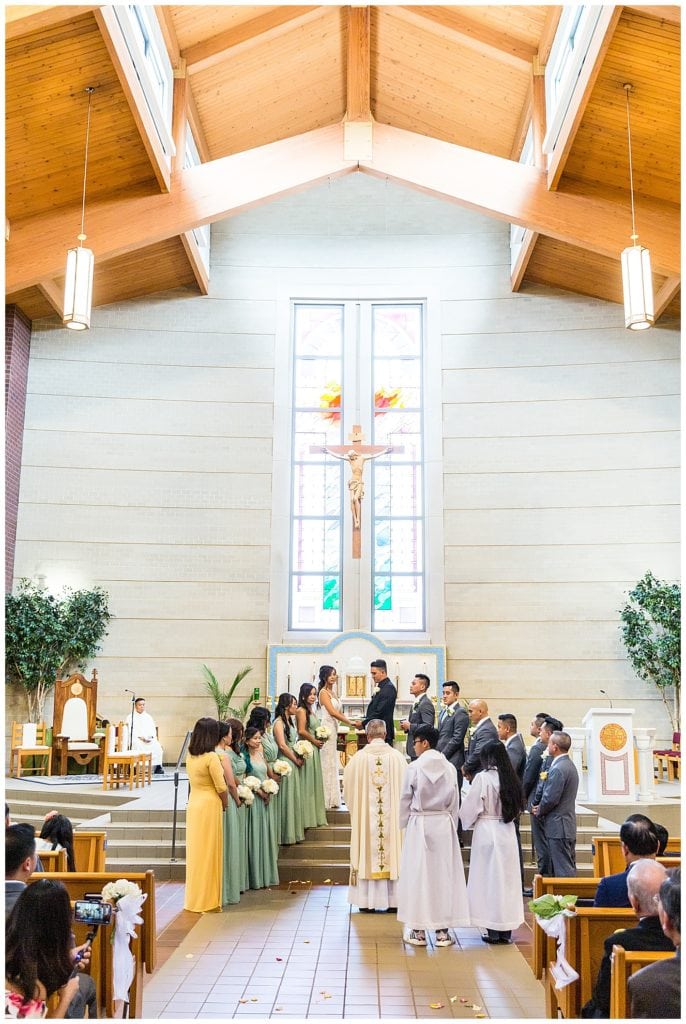 Full wedding party standing at alter in church wedding ceremony