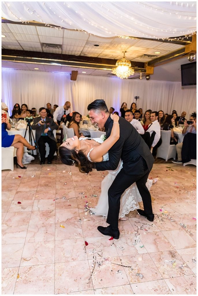 Groom dips bride during first dance at Golden City Restaurant wedding reception