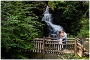 Bushkill Falls engagement session portrait in front of the falls on the timber bridge