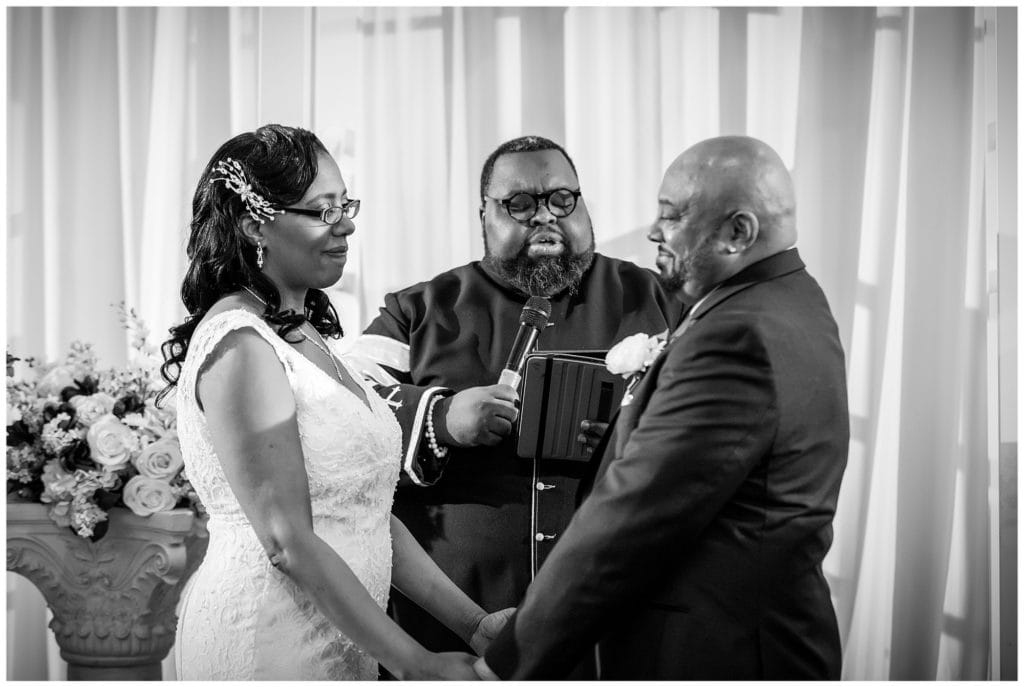 bride and groom holding hands during their wedding ceremony at the Windsor Ballroom