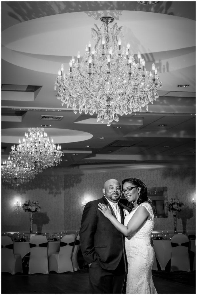 romantic portrait of bride and groom under the chandelier of the Windsor Ballroom