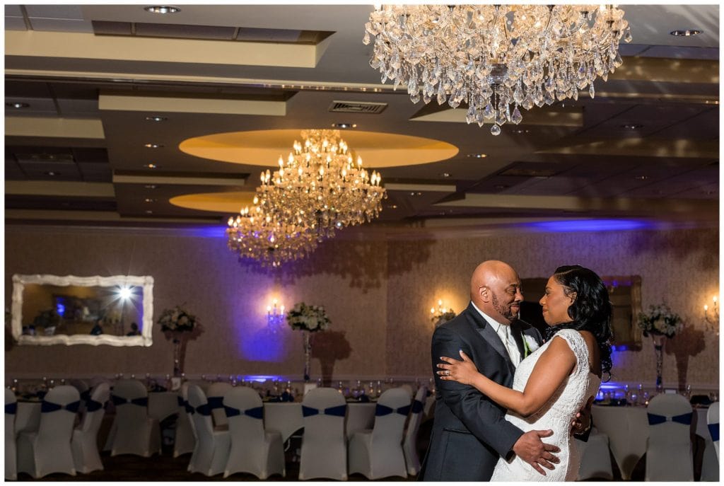 romantic portrait of bride and groom under the chandelier of the Windsor Ballroom