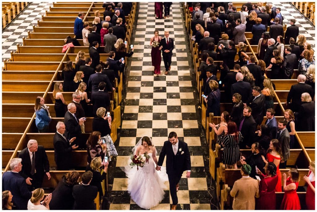 Bride and groom recessing aisle followed by wedding party in Church of the Gesu wedding, St. Joe's Prep wedding ceremony