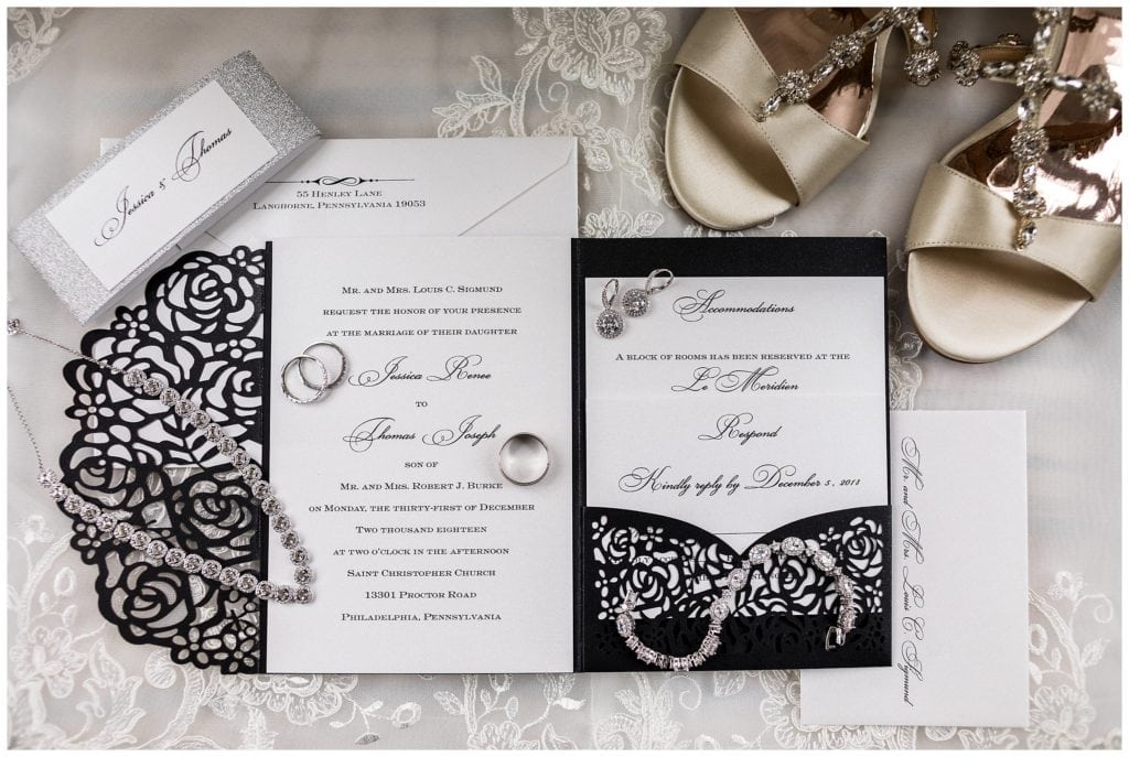Black and white floral wedding invitation suite for New Year's Eve wedding with wedding rings and bridal accessories