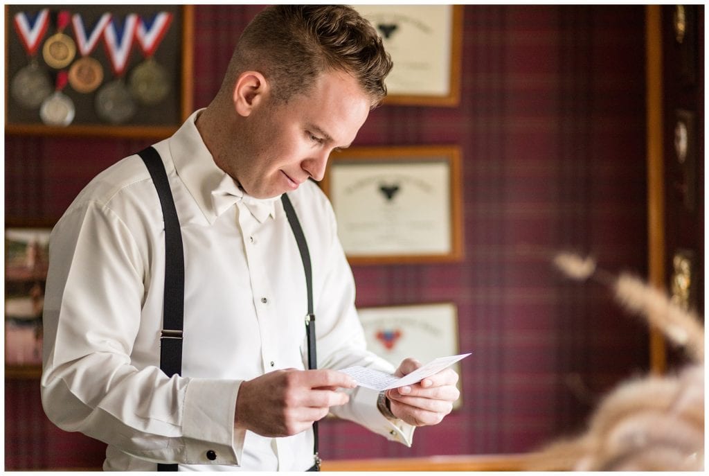 Window-lit portrait of groom reading letter from bride