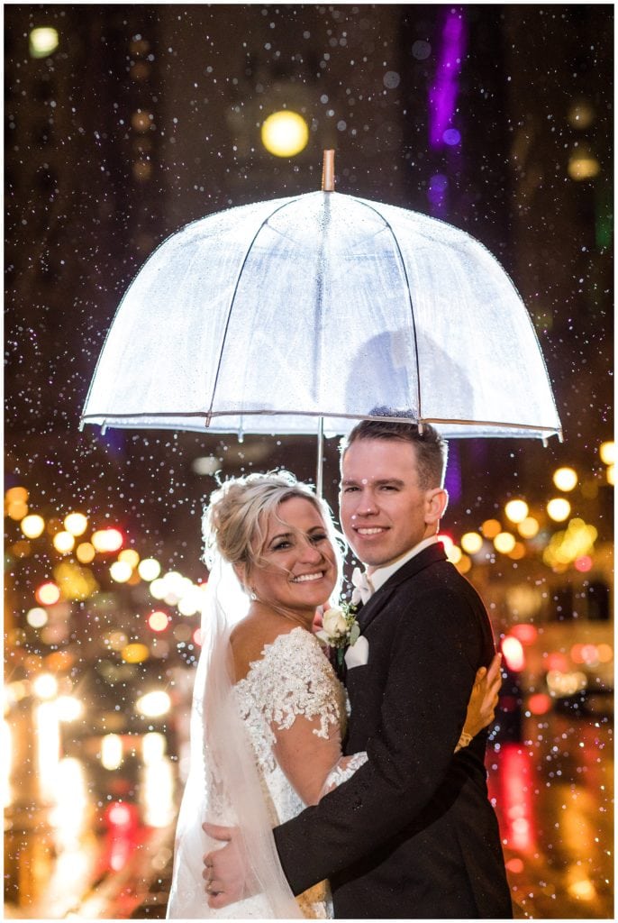 Bride and groom night rain shot with umbrella on Broad Street Philadelphia