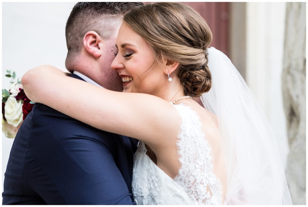 Bride and groom hug after first look at Second National Bank in Philadelphia