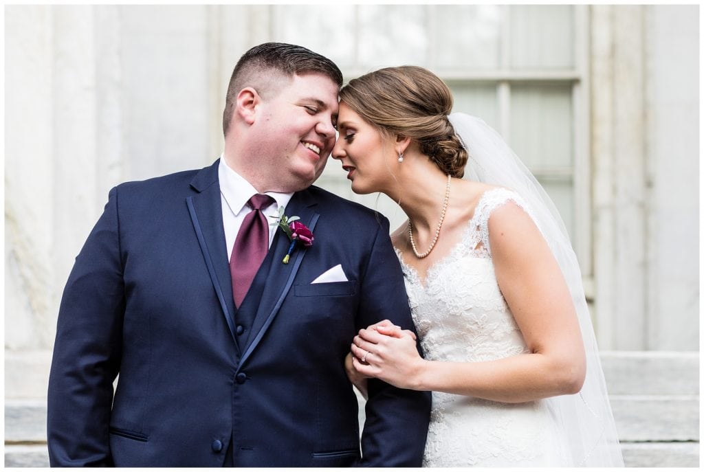 Bride and groom leaning in and smiling portrait