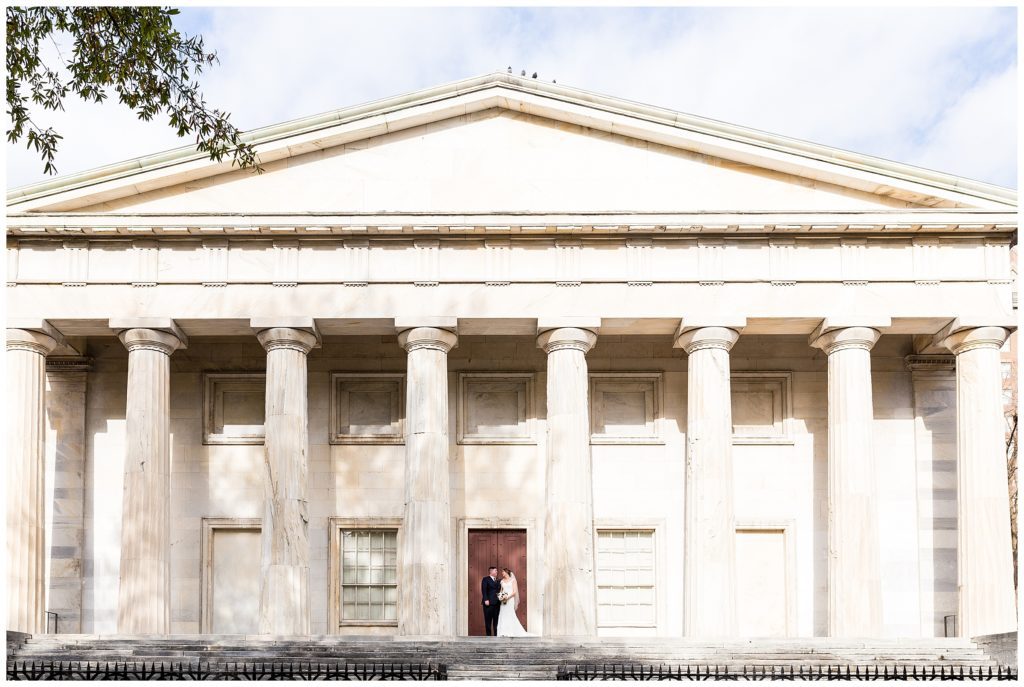 Wide bride and groom portrait in front of Second National Bank in Philadelphia