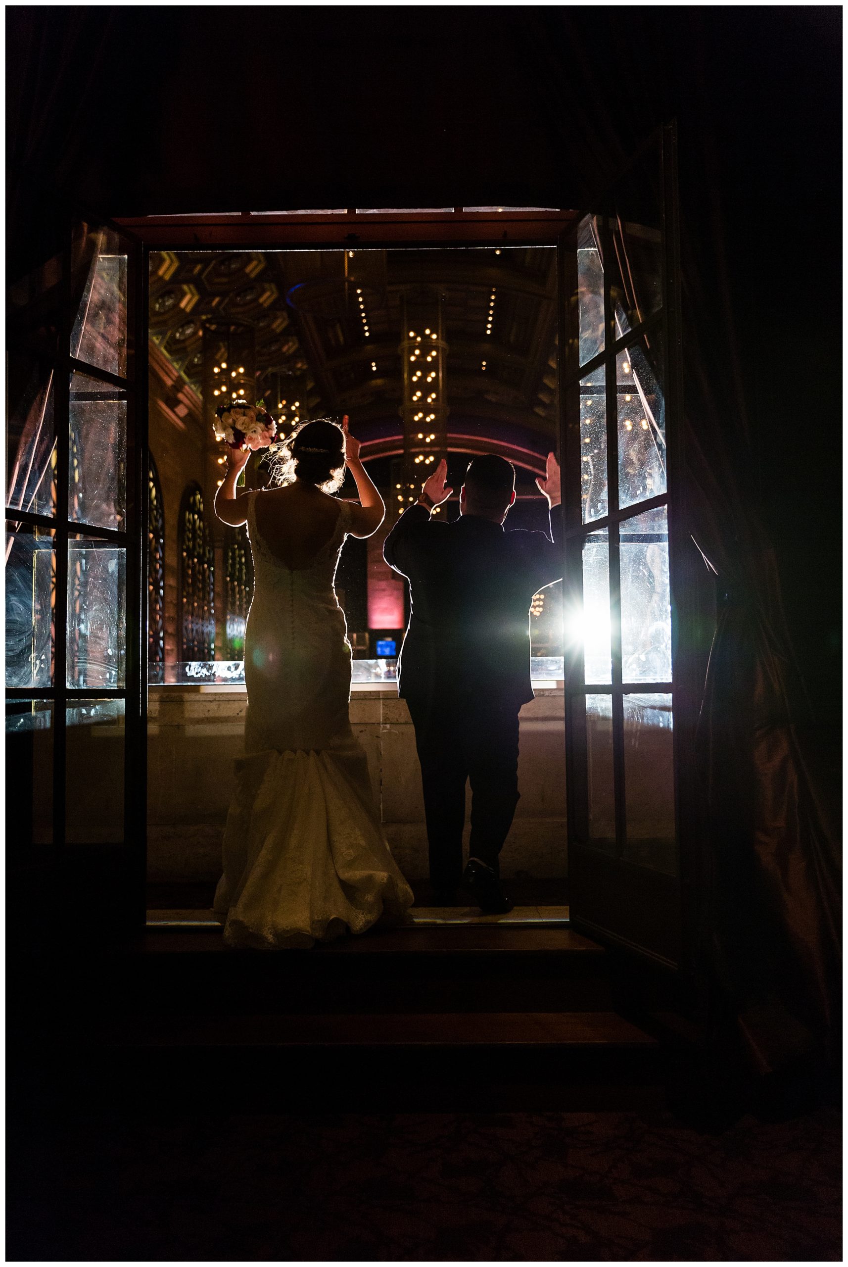 Bride and groom greet guests from balcony at Union Trust wedding