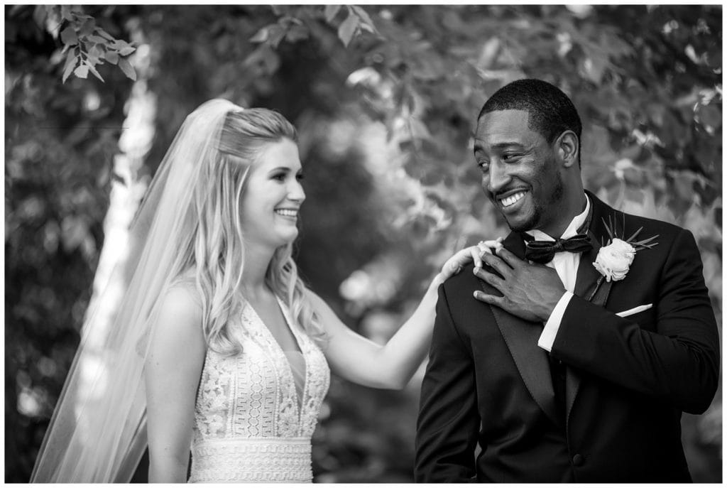 Black and white first look portrait with bride tapping groom on the shoulder