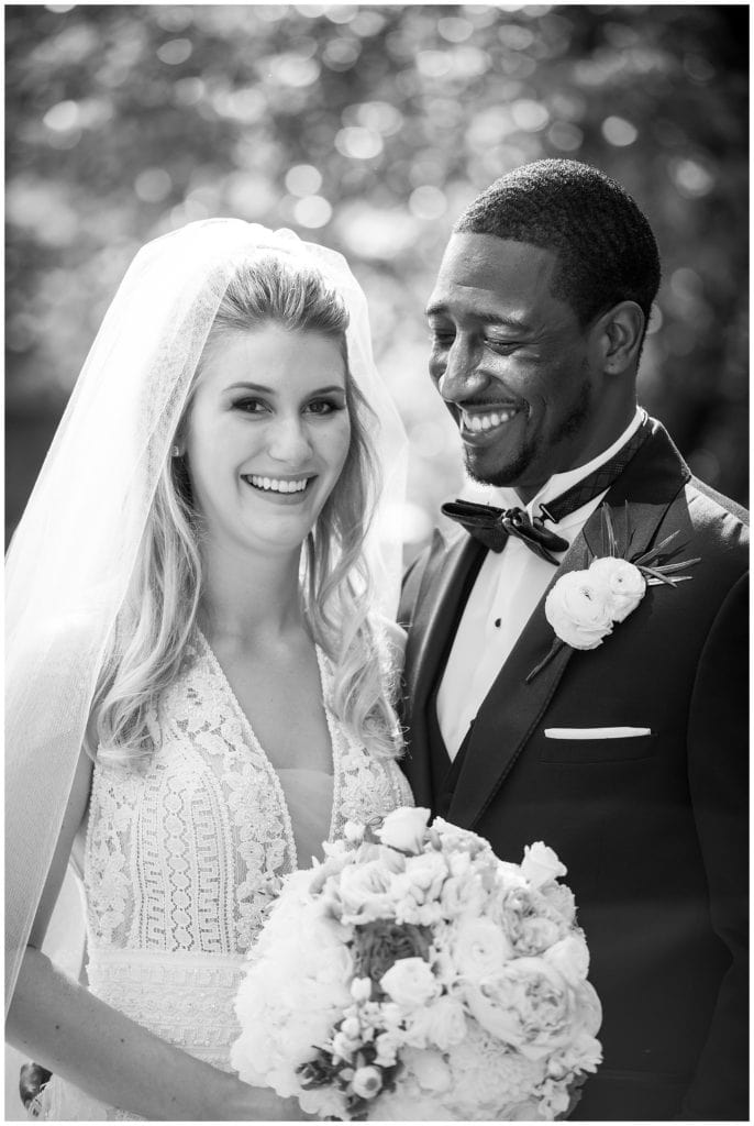 Black and white bride and groom portrait with groom smiling at bride