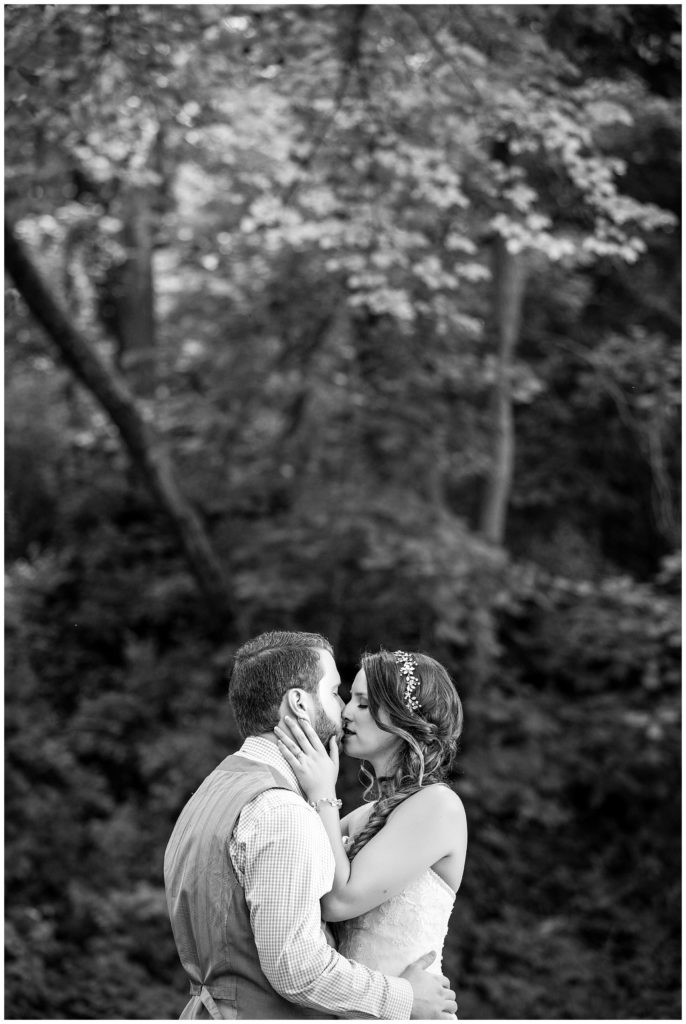 Black and white wedding portrait, bride and groom kissing