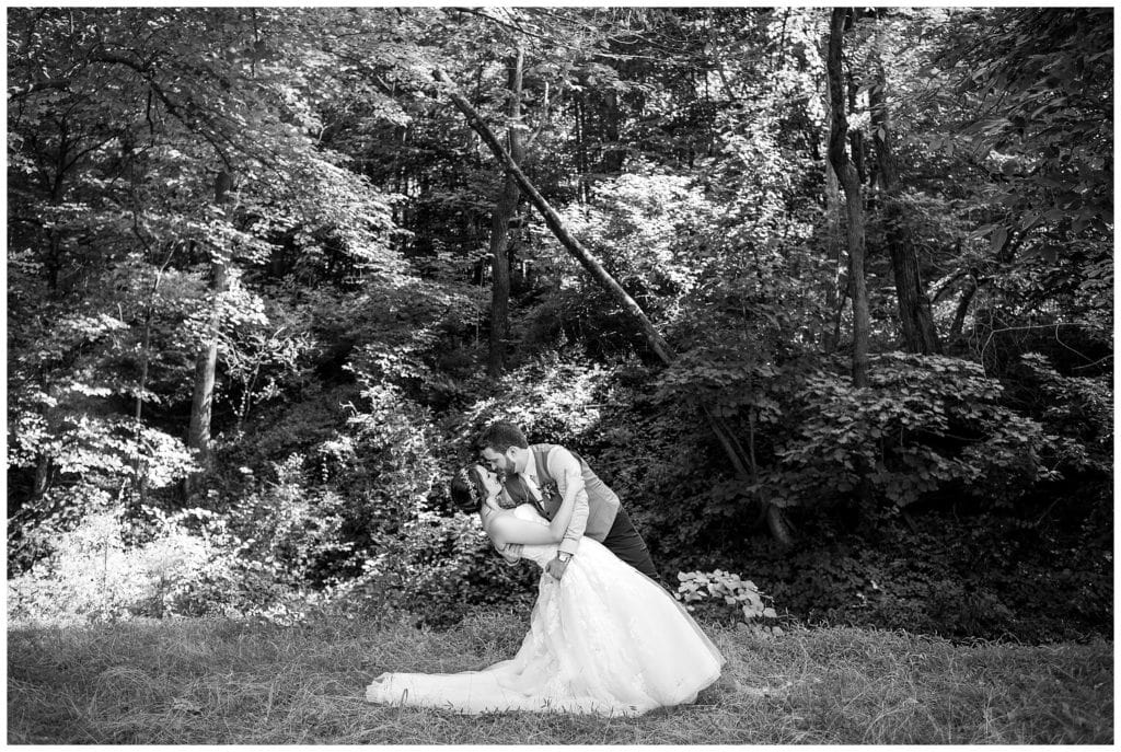 Black and white groom dipping bride portrait at Barn on Bridge wedding