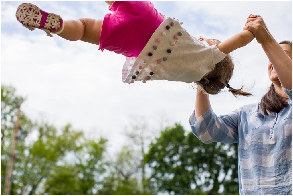 mom swinging her daughter during their day in the life family session