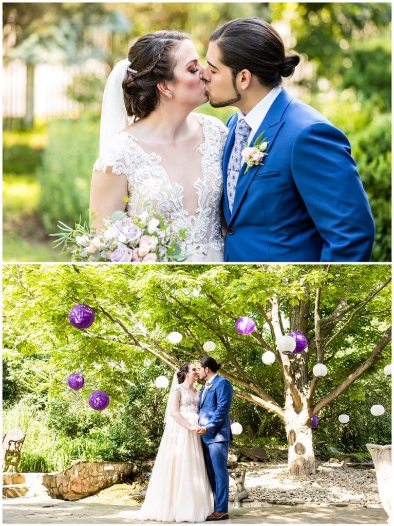Bride and groom kissing under tree with purple and white lanterns