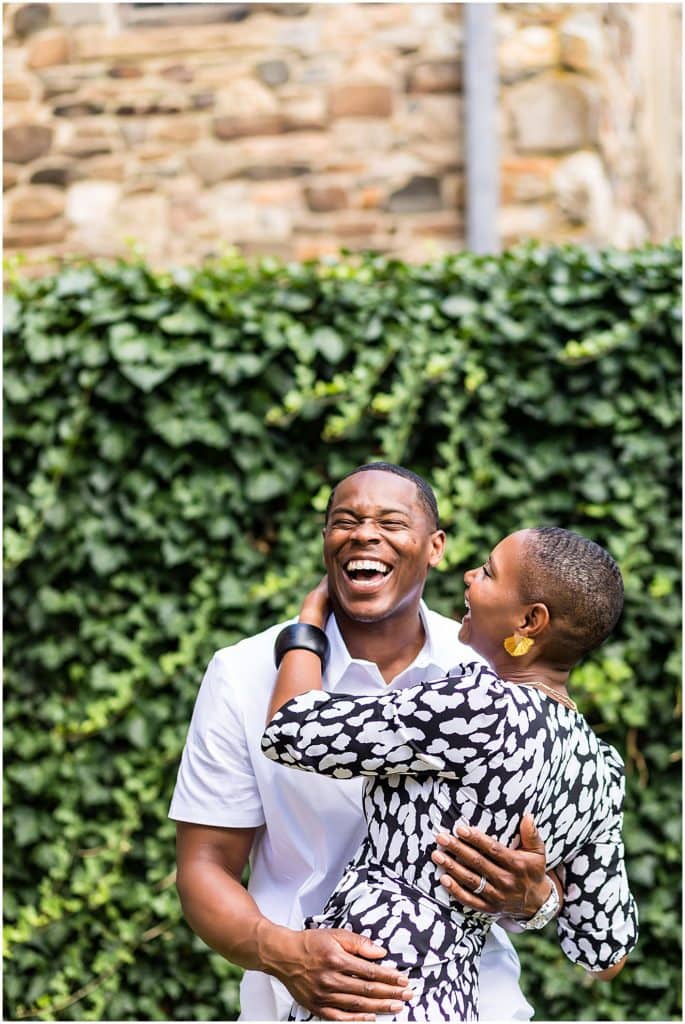 Couple laughing together while hugging at Hunting Hill Mansion at Ridley Creek State Park engagement session