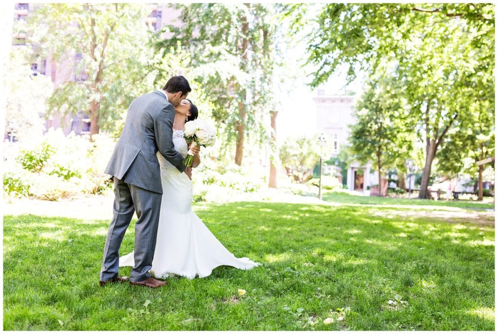Bride and groom kissing in park in Philadelphia wedding portrait
