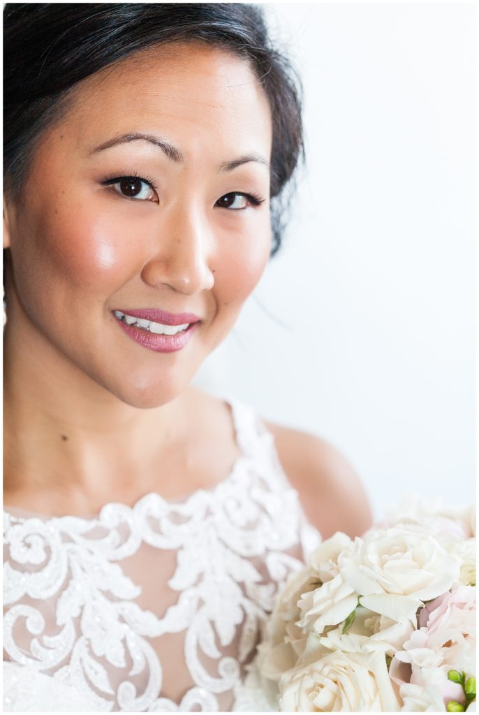 Traditional window lit bridal portrait with white rose bouquet