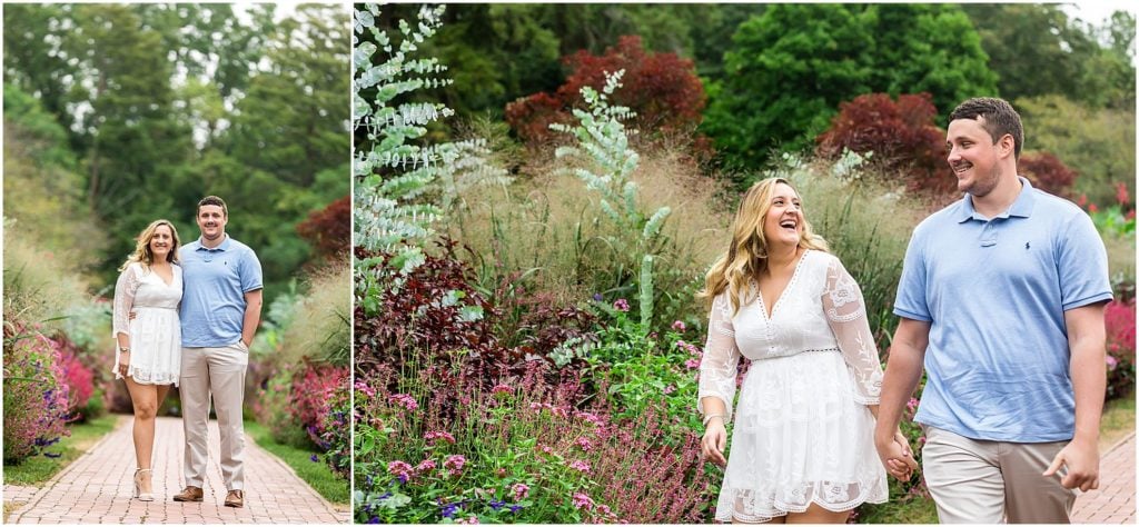 Traditional engagement portrait with couple walking through flowers at Longwood Gardens engagement session