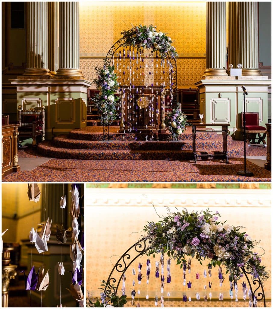 Wedding ceremony archway with florals and hanging origami paper cranes at One North Broad