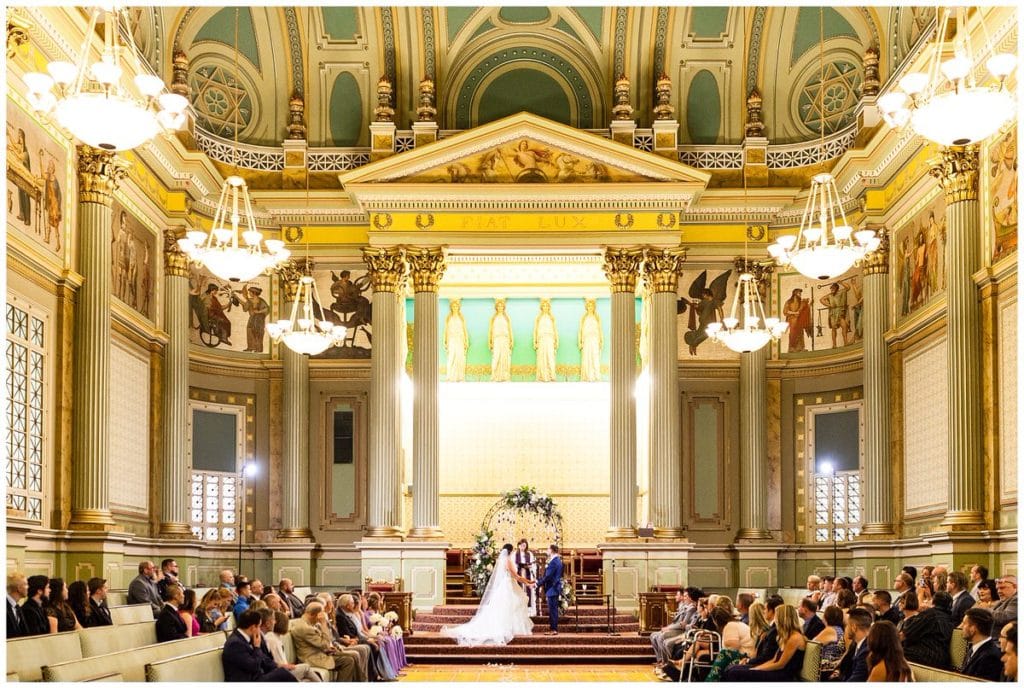 Bride and groom hold hands at alter at One North Broad wedding ceremony